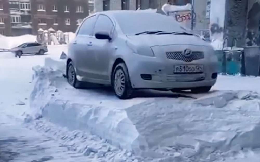 Метровый пьедестал: трактор почистил снег вокруг машин (видео)
