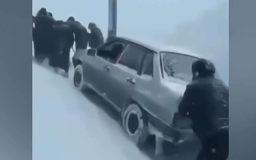 Женщины затащили в гору застрявшую в снегу машину