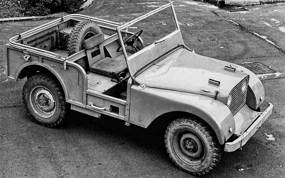 1947. Группа инженеров компании Rover под руководством Мориса Уилкса создала полноприводную машину на крепкой лестничной раме с простым по форме открытым алюминиевым кузовом - нечто среднее между трактором и автомобилем. На прототипе руль стоял посередине - чтобы при выполнении сельхозработ удобнее было контролировать ситуацию как слева, так и справа от машины. Фермерскому труженику дали соответствующее имя, оснастили его 1,6‑литровым бензиновым мотором мощностью 50 «лошадок», четырехступенчатой коробкой передач и раздаточной коробкой с понижающей передачей.